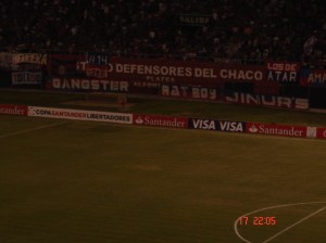 Marketing de Emboscada em futebol: Cerro x Corinthians, 17 Mar 2010, em Assunção. Notem que as faixas das marcas "Gangster", "Rat Boy" e "Jinur's" estão estrategicamente colocadas nas grades, próximas ao centro do campo. Não pagam pelos direitos comerciais do torneio, todavia estão lá. Um caso de marketing de emboscada. Marketing de Emboscada em futebol: Cerro x Corinthians, 17 Mar 2010, em Assunção. Notem que as faixas das marcas "Gangster", "Rat Boy" e "Jinur's" estão estrategicamente colocadas nas grades, próximas ao centro do campo. Não pagam pelos direitos comerciais do torneio, todavia estão lá. Um caso de marketing de emboscada.